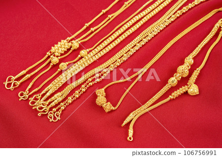 The Group of gold necklaces on red velvet fabric. The Group of gold necklaces on red velvet fabric. 106756991