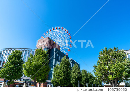 Yokohama cityscape, Japan, summer. In front of Center Kita Station, view of the cityscape including the Ferris wheel and Tsuzuki Hankyu against the blue sky = August Yokohama cityscape, Japan, summer. In front of Center Kita Station, view of the cityscape including the Ferris wheel and Tsuzuki Hankyu against the blue sky = August 106759060