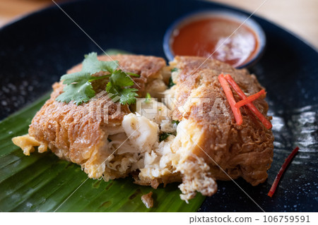 Omelet with crab meat served with sauce, on plate Omelet with crab meat served with sauce, on plate 106759591