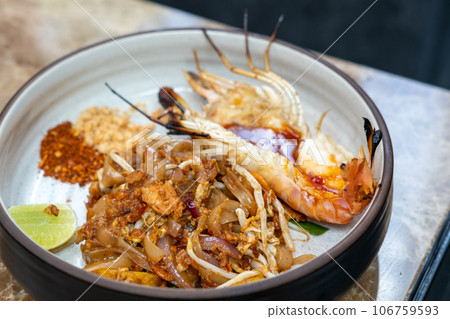 Pad Thai with river prawn serve on plate. It is a stir-fried rice noodle thai dish 106759593