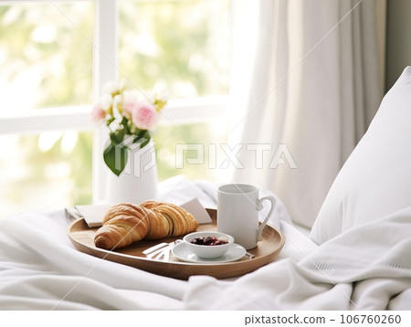 Beautiful cozy breakfast in bed, home bedroom interior with bright morning light, healthy food on decorated tray, weekend meal Beautiful cozy breakfast in bed, home bedroom interior with bright morning light, healthy food on decorated tray, weekend meal 106760260