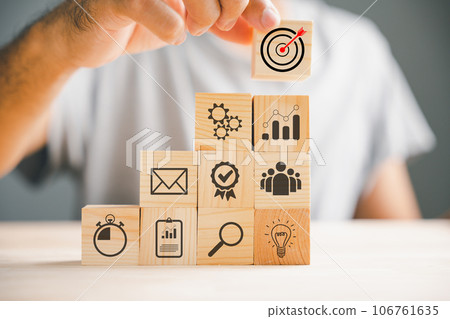 Hand skillfully arranging wood blocks with an arrow icon, emphasizing the concept of business strategy and Action plan. Copy space for professional projects. Hand skillfully arranging wood blocks with an arrow icon, emphasizing the concept of business strategy and Action plan. Copy space for professional projects. 106761635