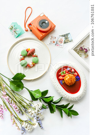 Background with desserts, polaroid camera and flowers. Top view on white table Background with desserts, polaroid camera and flowers. Top view on white table 106761881