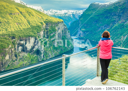 Tourist looking at Geirangerfjord from Flydasjuvet viewpoint Norway 106762143