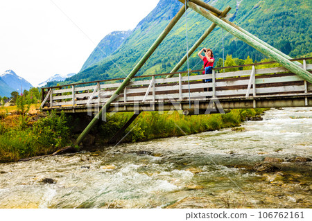 Tourist relaxing on bridge in village Oppstryn Norway Tourist relaxing on bridge in village Oppstryn Norway 106762161