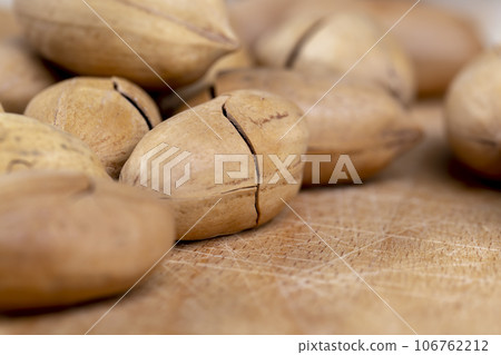 cracked unpeeled pecans close-up on the table 106762212