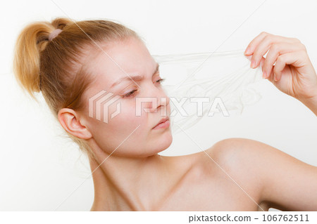 Woman removing facial peel off mask. 106762511