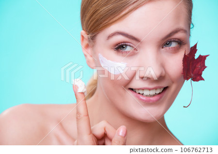 Skin care. Face of young woman girl with red maple leaf. 106762713