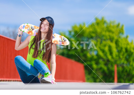 Teenage girl skater riding skateboard on street. Teenage girl skater riding skateboard on street. 106762742