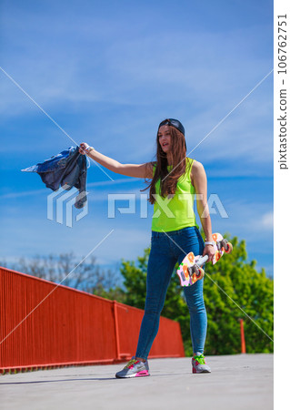 Teenage girl skater riding skateboard on street. 106762751