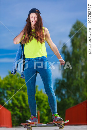 Teen girl skater riding skateboard on street. 106762767
