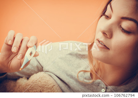 Sick ill woman with digital thermometer. 106762794