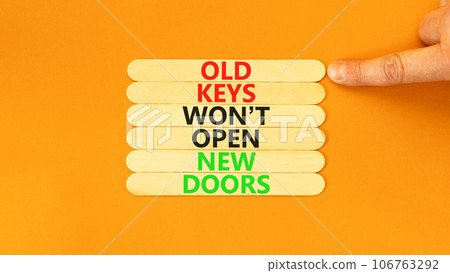 Old keys do not open new doors symbol. Concept words Old keys do not open new doors. Businessman hand. Beautiful orange background. Business, popular quotation old key new door concept. Copy space. Old keys do not open new doors symbol. Concept words Old keys do not open new doors. Businessman hand. Beautiful orange background. Business, popular quotation old key new door concept. Copy space. 106763292