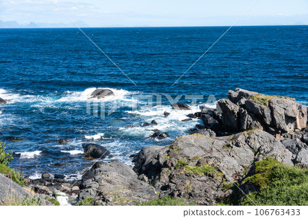 The deep blue Ocean with waves crashing on a rocky island. rugged, rocky coastline at the Sea The deep blue Ocean with waves crashing on a rocky island. rugged, rocky coastline at the Sea 106763433