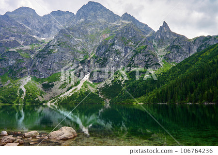 Amazing view on mountains range near beautiful lake at summer day. Tatra National Park in Poland. Panoramic view on Morskie Oko or Sea Eye lake in Five lakes valley 106764236
