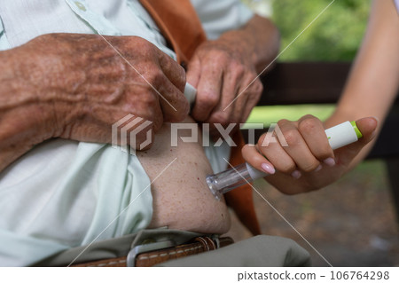Nurse injecting insulin in belly of diabetic senior patient 106764298