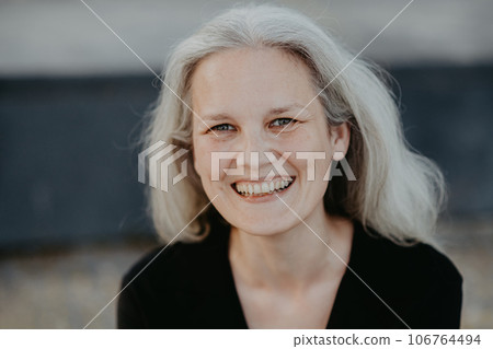 Portrait of beautiful smiling woman in middle age with gray hair. 106764494