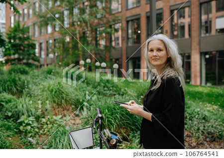 Female city commuter traveling from work by bike after a long workday. Female city commuter traveling from work by bike after a long workday. 106764541