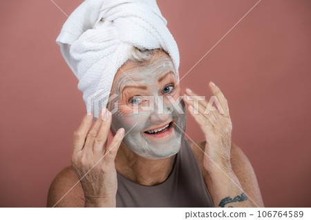 Portrait of happy senior woman with face-mask, selfcare and skin routine concept. 106764589