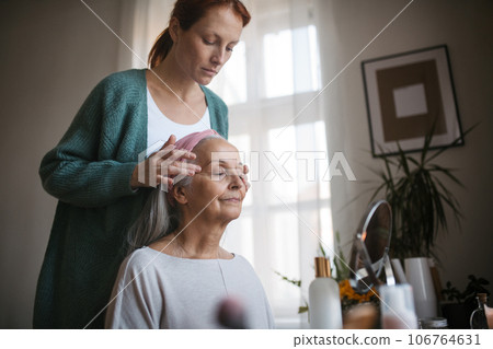 Mature daughter giving facial massage to her mother. 106764631