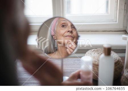 Senior woman making make up herself at home. 106764635