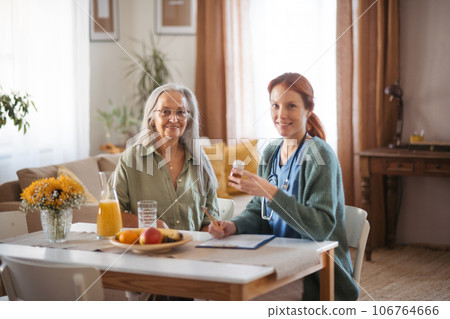 Nurse explaining senior woman how to take medicine. Nurse explaining senior woman how to take medicine. 106764666