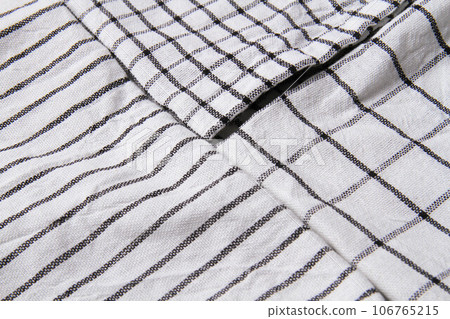 Plaid material. Towel on the table. Wrinkled fabric with stripes. Plaid material. Towel on the table. Wrinkled fabric with stripes. 106765215