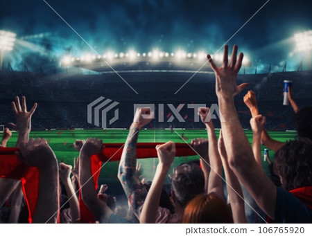 Football scene at night match with with cheering fans at the stadium Football scene at night match with with cheering fans at the stadium 106765920