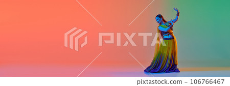 Indian beautiful woman dancing traditional dance in elegant dress against white studio background 106766467