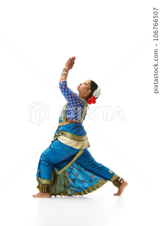 Elegant, artistic indian woman in traditional dress dancing against white studio background Elegant, artistic indian woman in traditional dress dancing against white studio background 106766507