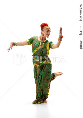 Artistic dancer, woman in traditional indian dress dancing against white studio background 106766520