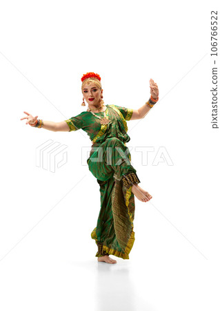 Artistic dancer, woman in traditional indian dress dancing against white studio background 106766522