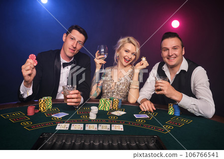 Group of a young wealthy friends are playing poker at a casino. 106766541
