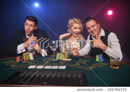 Group of a young wealthy friends are playing poker at a casino. Group of a young wealthy friends are playing poker at a casino. 106766555