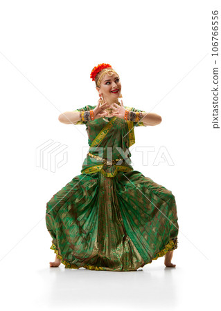 Indian dance pose. Beautiful woman in traditional indian dress dancing against white studio background Indian dance pose. Beautiful woman in traditional indian dress dancing against white studio background 106766556