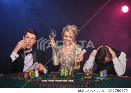 Group of a young wealthy friends are playing poker at a casino. 106766575