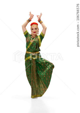 Beautiful, elegant, young woman in traditional indian dress dancing against white studio background 106766576