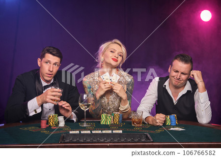 Group of a young wealthy friends are playing poker at a casino. Group of a young wealthy friends are playing poker at a casino. 106766582