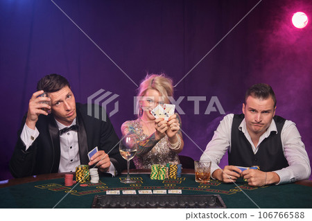 Group of a young wealthy friends are playing poker at a casino. 106766588