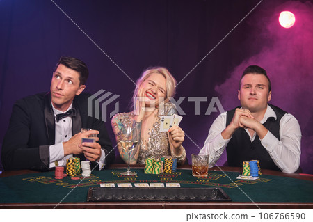 Group of a young wealthy friends are playing poker at a casino. Group of a young wealthy friends are playing poker at a casino. 106766590