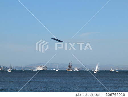 four Blue Angels fly by a flotilla of boats in San Francisco Bay during fleet week 106766910