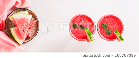 Watermelon lemonade with watermelon pieces in glasses on pink background top view web banner Watermelon lemonade with watermelon pieces in glasses on pink background top view web banner 106767089