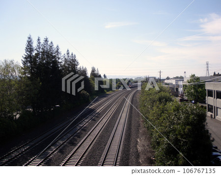 four lane train track with distant train rolling though four lane train track with distant train rolling though 106767135