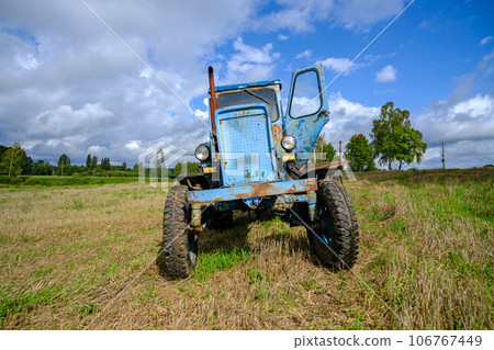 Old blue Russian agricultural tractors in the field. Agricultural machinery in the farm. Special Agricultural Equipment. Durable agricultural machinery Old blue Russian agricultural tractors in the field. Agricultural machinery in the farm. Special Agricultural Equipment. Durable agricultural machinery 106767449