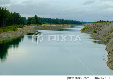 This is a former shale quarry with azure water and picturesque hills. Unlike the Narva shale settling ponds. A dark autumn day. Estonia, Aidu quarry. This is a former shale quarry with azure water and picturesque hills. Unlike the Narva shale settling ponds. A dark autumn day. Estonia, Aidu quarry. 106767497
