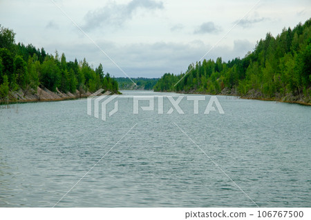 This is a former shale quarry with azure water and picturesque hills. Unlike the Narva shale settling ponds. A dark autumn day. Estonia, Aidu quarry. This is a former shale quarry with azure water and picturesque hills. Unlike the Narva shale settling ponds. A dark autumn day. Estonia, Aidu quarry. 106767500