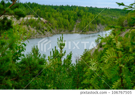 This is a former shale quarry with azure water and picturesque hills. Unlike the Narva shale settling ponds. A dark autumn day. Estonia, Aidu quarry. This is a former shale quarry with azure water and picturesque hills. Unlike the Narva shale settling ponds. A dark autumn day. Estonia, Aidu quarry. 106767505