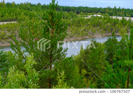 This is a former shale quarry with azure water and picturesque hills. Unlike the Narva shale settling ponds. A dark autumn day. Estonia, Aidu quarry. This is a former shale quarry with azure water and picturesque hills. Unlike the Narva shale settling ponds. A dark autumn day. Estonia, Aidu quarry. 106767507