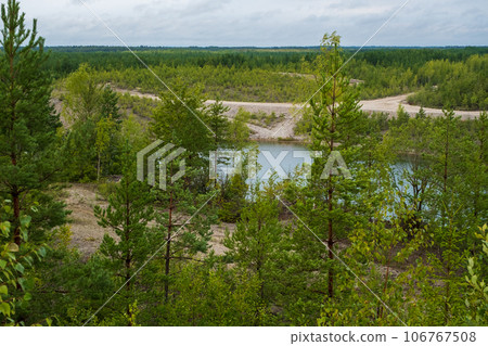 This is a former shale quarry with azure water and picturesque hills. Unlike the Narva shale settling ponds. A dark autumn day. Estonia, Aidu quarry. This is a former shale quarry with azure water and picturesque hills. Unlike the Narva shale settling ponds. A dark autumn day. Estonia, Aidu quarry. 106767508