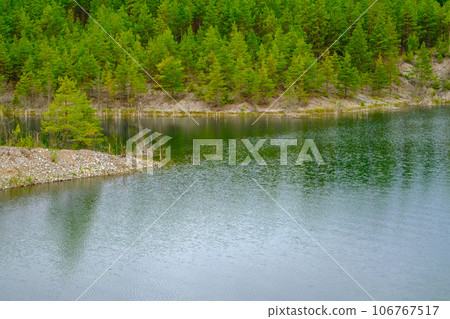 This is a former shale quarry with azure water and picturesque hills. Unlike the Narva shale settling ponds. A dark autumn day. Estonia, Aidu quarry. This is a former shale quarry with azure water and picturesque hills. Unlike the Narva shale settling ponds. A dark autumn day. Estonia, Aidu quarry. 106767517